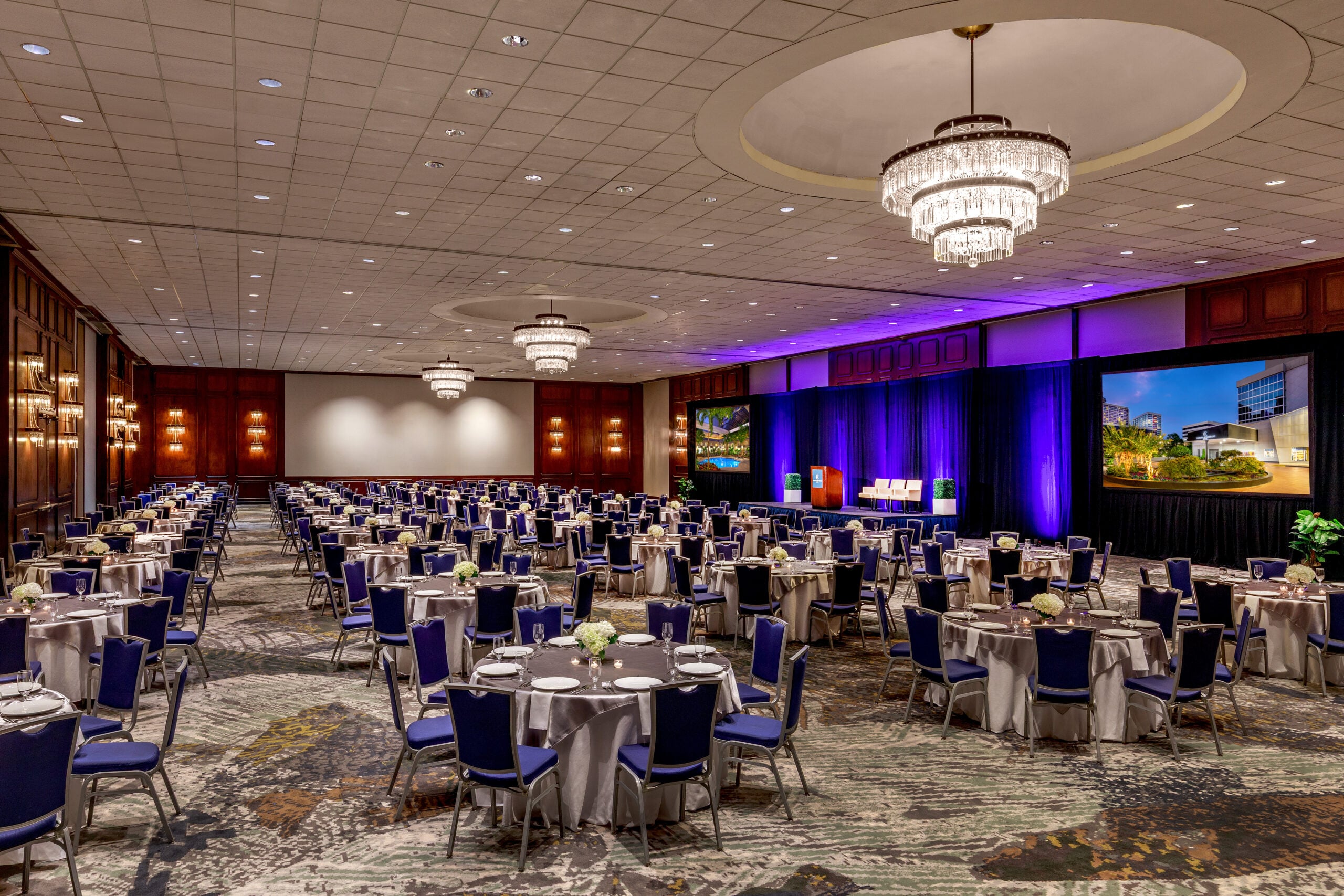 The Capitol Ballroom set for The Mayhem Ball — crystal chandeliers, banquet round tables, purple-lit stage